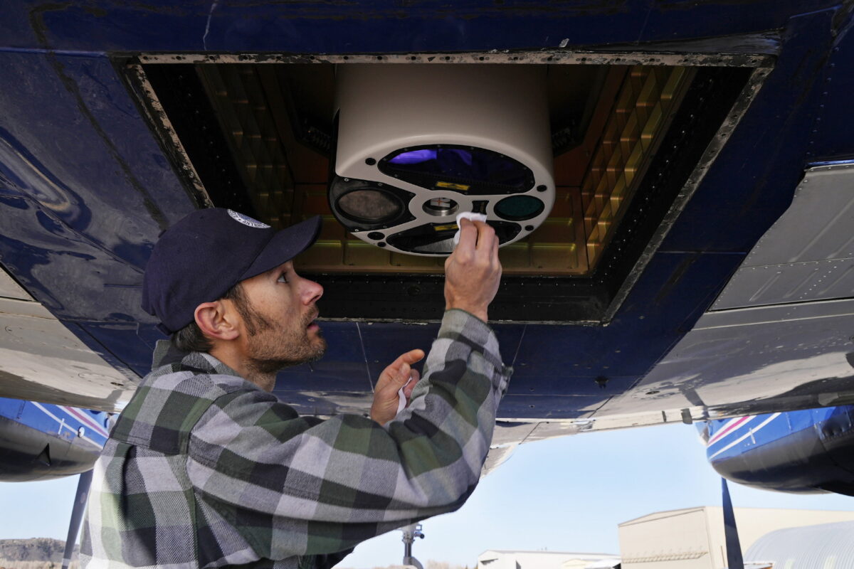 An engineer with Airborne Snow Observatories, cleans a laser mapping device