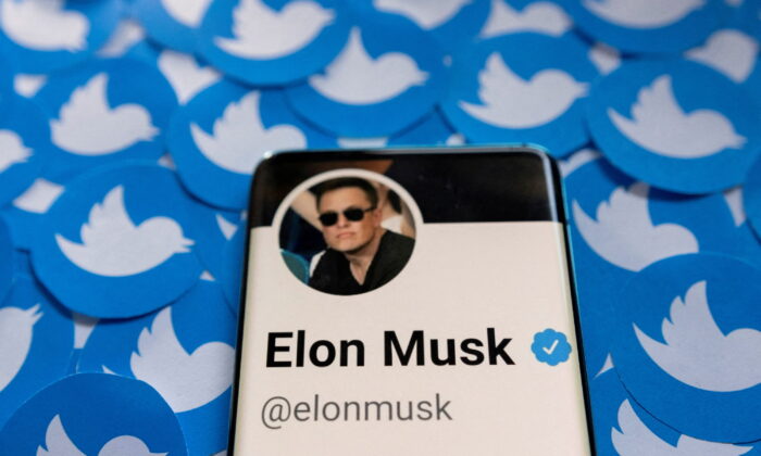 Elon Musk's Twitter profile is seen on a smartphone placed on printed Twitter logos in this illustration taken April 28, 2022. (Reuters/Dado Ruvic/Illustration)