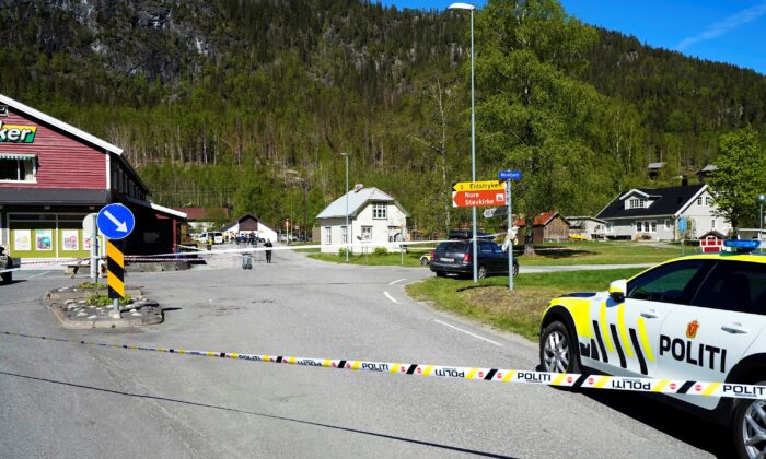 A police vehicle is parked behind a barrier tape on the side of the road, following attacks, in Nore, Numedal region, Norway, on May 20, 2022. (Lise Aserud/NTB/via Reuters)
