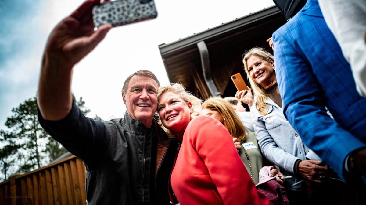 Former Sen. David Perdue poses for a selfie with a supporter on March 7, 2022, in Commerce, Ga., during his campaign to replace incumbent Gov. Brian Kemp. (Courtesy of the Perdue for Governor campaign)