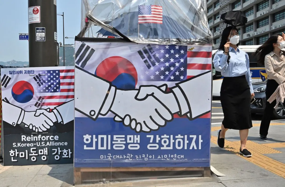 Pedestrians walk past banners calling for strengthening of the South Korea-US alliance near the U.S. embassy in Seoul on May 20, 2022, ahead of U.S. President Joe Biden's visit to South Korea. (Jung Yeon-je/AFP via Getty Images)