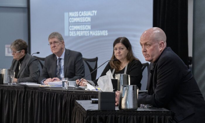 RCMP Cpl. Duane Ivany, a member of the force's emergency medical response team, fields questions as commissioners Leanne Fitch, Michael MacDonald, chair, and Kim Stanton, left to right, look on at the Mass Casualty Commission inquiry into the mass murders in rural Nova Scotia on April 18/19, 2020, in Dartmouth, N.S. on May 5, 2022. (The Canadian Press/Andrew Vaughan)