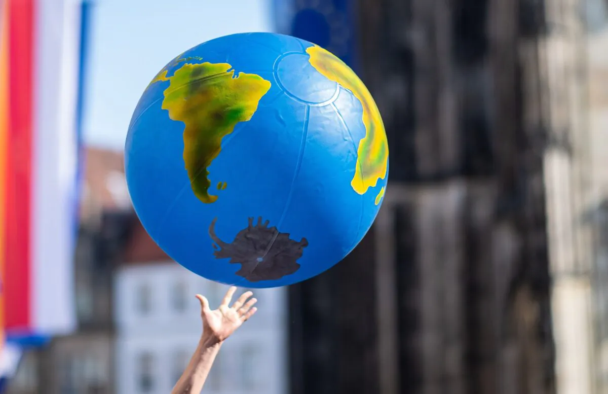 A student reaches for an inflated globe during a "Fridays for Future" protest for urgent climate action in Muenster, northwestern Germany, on May 24, 2019. (Guido Kirchner/dpa/AFP via Getty Images)