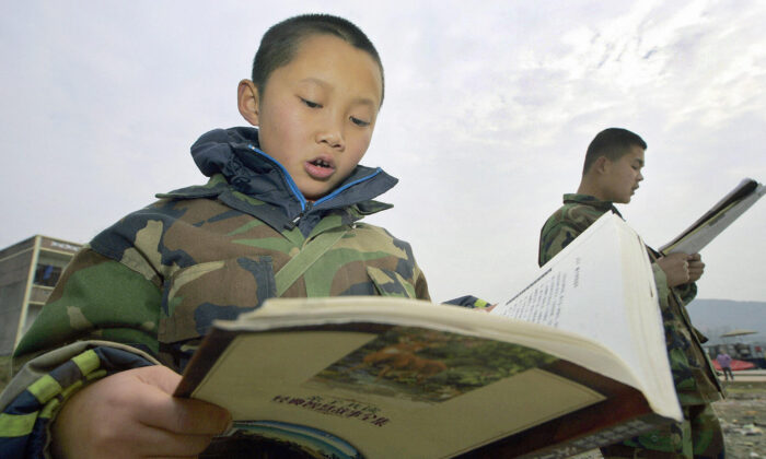 Students read textbooks at the temporary campus of the "Walking School" of Xu Xiangyang Education and Training Group, 22 Dec., 2005, on the outskirts of  Chengdu.  (Liu Jin/AFP via Getty Images)