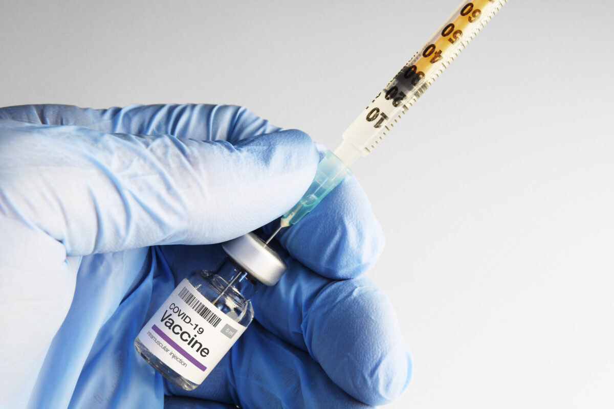 A syringe inserted into a COVID-19 vaccine vial. (Robert Avgustin/Shutterstock)
