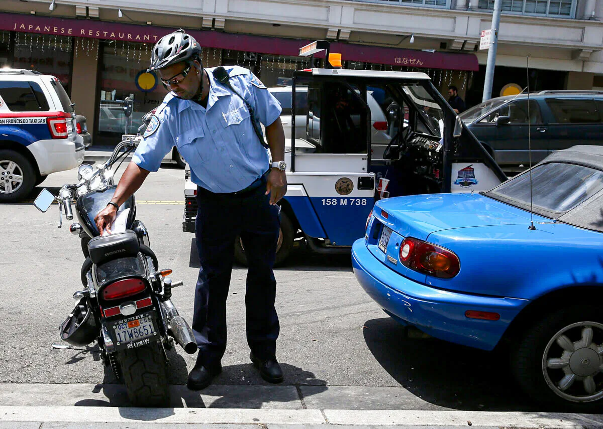 A San Francisco Municipal Transportation Agency parking control officer places a parking ticket for an illegally parked motorcycle on July 3, 2013 in San Francisco, Calif. (Justin Sullivan/Getty Images)