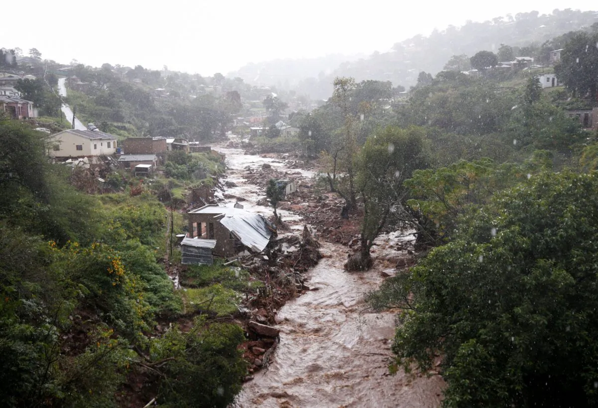 A river runs high after heavy rains, next to homes which were damaged during previous flooding, in kwaNdengezi near Durban, South Africa, on May 22, 2022. (Rogan Ward/Reuters)
