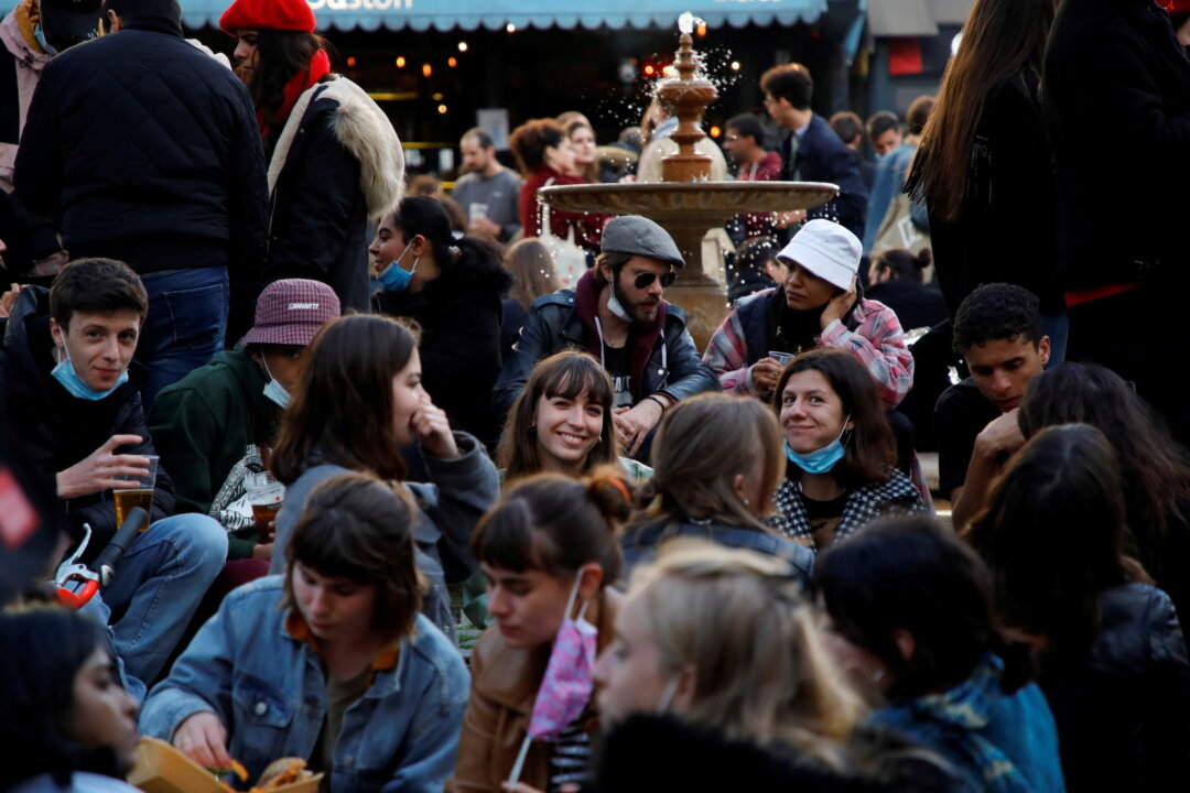 People enjoy an evening drink at Place de la Contrescarpe in Paris as cafes, bars, and restaurants reopen after closing down for months amid the COVID-19 outbreak in France, on May 19, 2021. (Sarah Meyssonnier/Reuters)