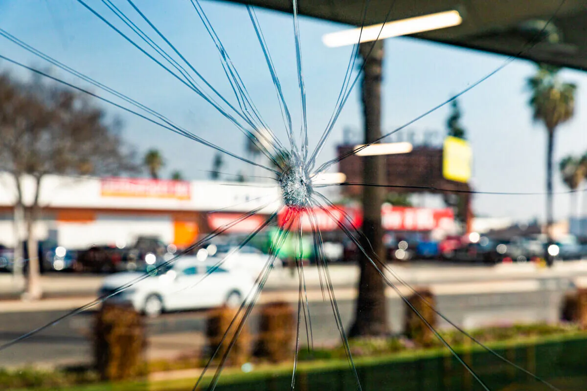 A bullet hole is seen on a French window of a furniture store in Anaheim, Calif., on Feb. 11, 2021. (John Fredricks/The Epoch Times)