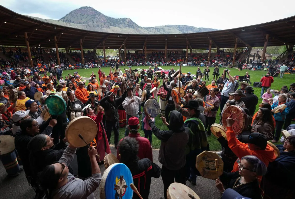 Drummers play and sing during a ceremony to mark the one-year anniversary of the Tk’emlúps te Secwépemc announcement of the detection of possible remains of 215 children at an unmarked burial site at the former Kamloops Indian Residential School, in Kamloops, B.C., on May 23, 2022. (The Canadian Press/Darryl Dyck)