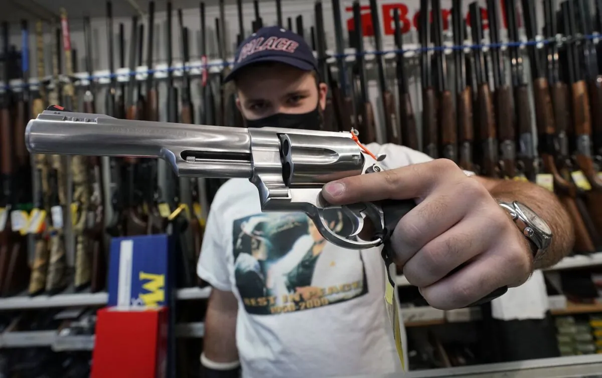 A salesman shows off weapons for sale at Coliseum Gun Traders Ltd. in Uniondale, New York on Sept. 25, 2020. (Timothy A. Clary/AFP via Getty Images)