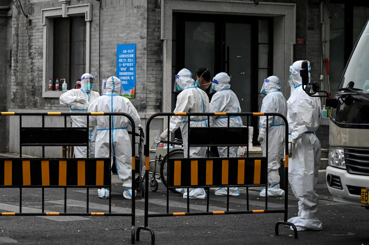 Workers wearing personal protective equipment (PPE) are seen at an entrance to an alley in a neighbourhood under lockdown in Beijing on May 24, 2022. (Jade Gao/AFP via Getty Images)