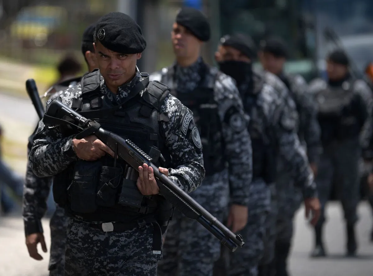 Police stand guard during a protest against the killing of 24-year-old Congolese refugee Moise Kabagambe at the site of his death in Rio de Janeiro, Brazil on Feb. 5, 2022. (Carl De Souza/AFP via Getty Images)