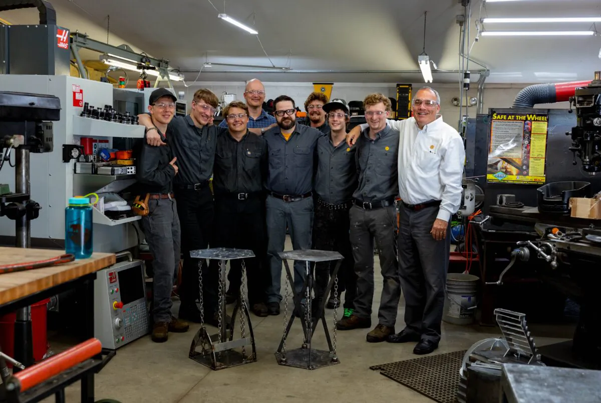 Harmel Academy students and faculty gather in the workshop for a group photo.（Rob Shumaker）