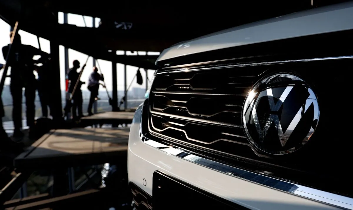 The storage facility auto tower of German carmaker Volkswagen is reflected in a VW logo at the company's headquarters in Wolfsburg, northern Germany, on March 26, 2021. (Ronny Hartmann/AFP via Getty Images)