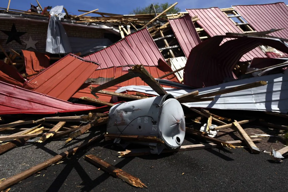 A segment from a utility pole is seen in a residence’s driveway, along with the roof of a hardware store that lifted off and crashed into neighbouring houses during a major weekend storm, in the community of Hammond in Clarence-Rockland, Ont., on May 23, 2022. (The Canadian Press/Justin Tang)