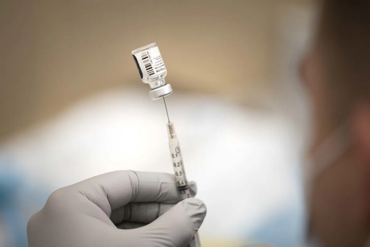 A Navy member prepares a COVID-19 vaccine dose at a vaccination site in a file image. (DOD Photo by Navy Petty Officer 1st Class Carlos M. Vazquez II via The Epoch Times)