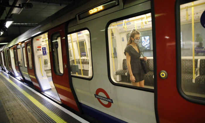 A passenger wears a mask as she boards a London Underground tube train in London on July 17, 2020. (Tolga Akmen/AFP via Getty Images)