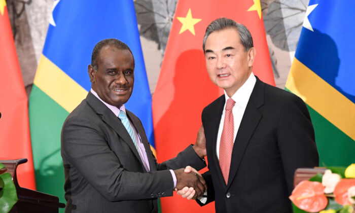 Solomon Islands Foreign Minister Jeremiah Manele (L) shakes hands with Chinese State Councilor and Foreign Minister Wang Yi (R) to mark the establishment of diplomatic ties between the two nations at the Diaoyutai State Guesthouse in Beijing, China on September, 2019. (Naohiko Hatta - Pool/Getty Images)