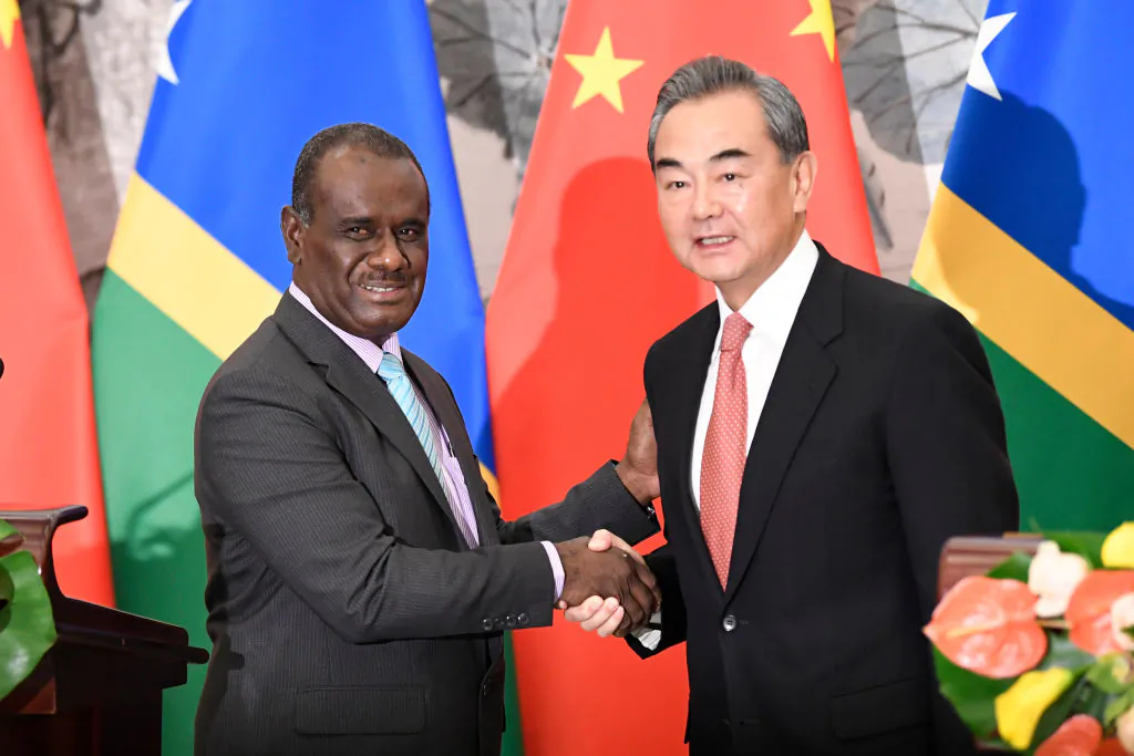Solomon Islands Foreign Minister Jeremiah Manele (L) shakes hands with Chinese State Councilor and Foreign Minister Wang Yi (R) to mark the establishment of diplomatic ties between the two nations at the Diaoyutai State Guesthouse in Beijing, China on September, 2019. (Naohiko Hatta - Pool/Getty Images)