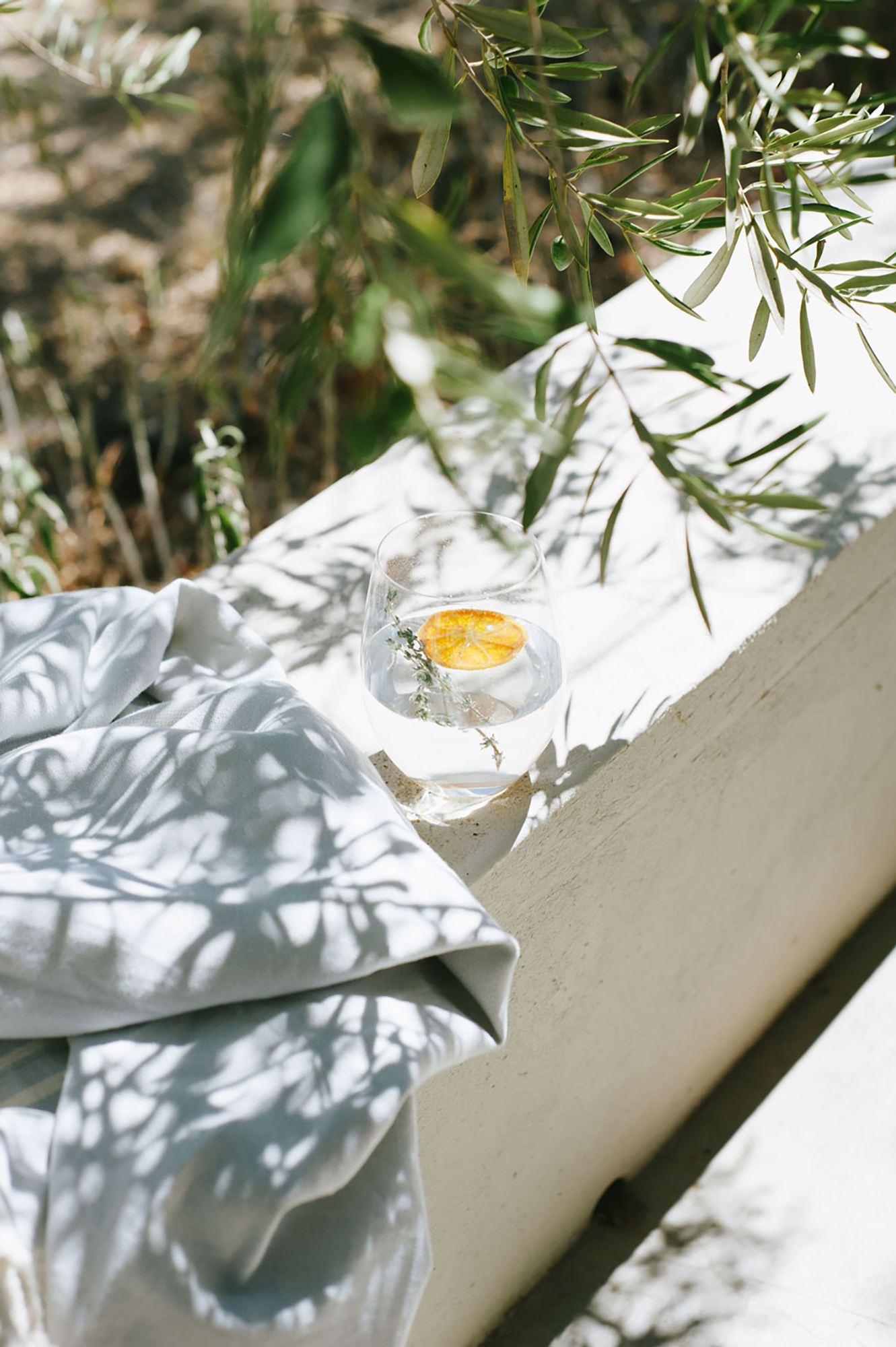 A gin and tonic sitting in the dappled shade