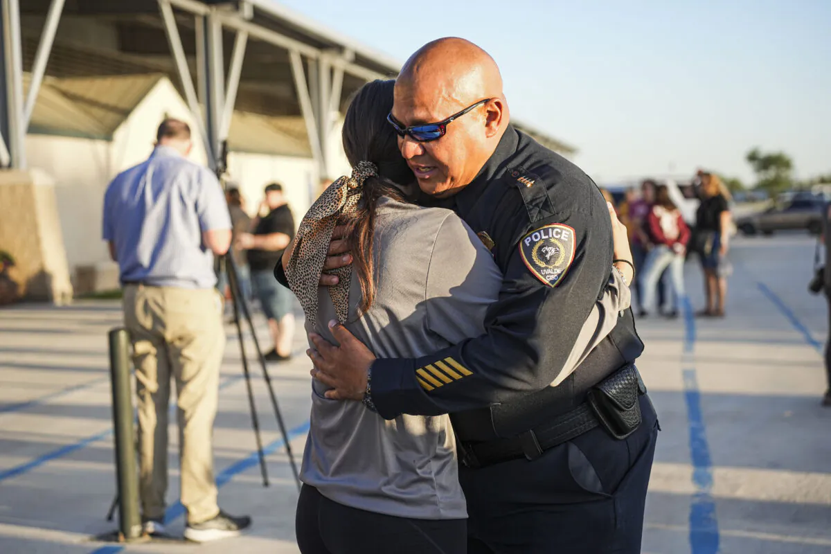Uvalde school district Chief of Police Pete Arredondo hugs a school student at a community prayer evening held the day after a mass shooting at Robb Elementary School that killed 19 children and two teachers, in Uvalde, Texas, on May 25, 2022. (Charlotte Cuthbertson/The Epoch Times)