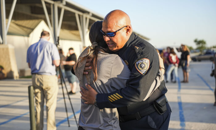 Uvalde school district Chief of Police Pete Arredondo hugs a school student at a community prayer evening held the day after a mass shooting at Robb Elementary School that killed 19 children and two teachers, in Uvalde, Texas, on May 25, 2022. (Charlotte Cuthbertson/The Epoch Times)