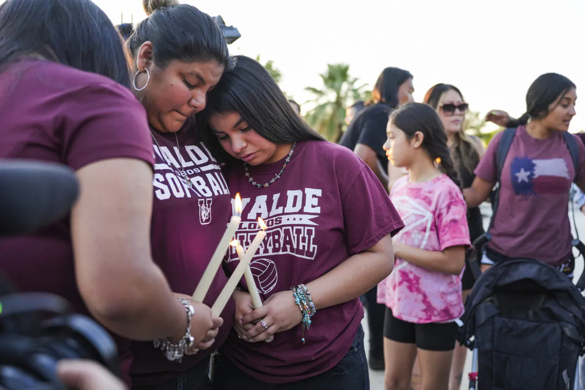 Uvalde school children comfort each other at a community prayer evening held the day after a mass shooting at Robb Elementary School that killed 19 children and 2 teachers, in Uvalde, Texas, on May 25, 2022. (Charlotte Cuthbertson/The Epoch Times)