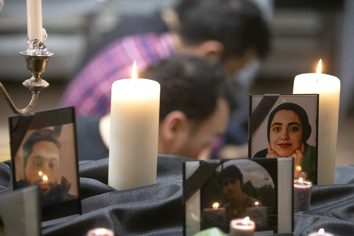 Photos of some of the victims stand among candles as members of Toronto's Iranian community attend a vigil in Toronto on Jan. 8, 2020, to mourn victims of Ukraine International Airlines Flight PS752 that crashed after takeoff near Tehran, Iran. (The Canadian Press/Chris Young)