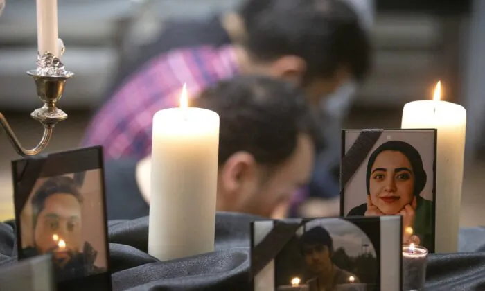 Photos of some of the victims stand among candles as members of Toronto's Iranian community attend a vigil in Toronto on Jan. 8, 2020, to mourn victims of Ukraine International Airlines Flight PS752 that crashed after takeoff near Tehran, Iran. (The Canadian Press/Chris Young)