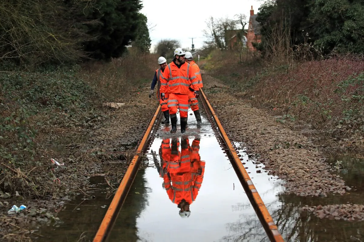 Network Rail employees walking up the flooded line near Snaith, east Yorkshire, on April 26, 2022. (PA Media)