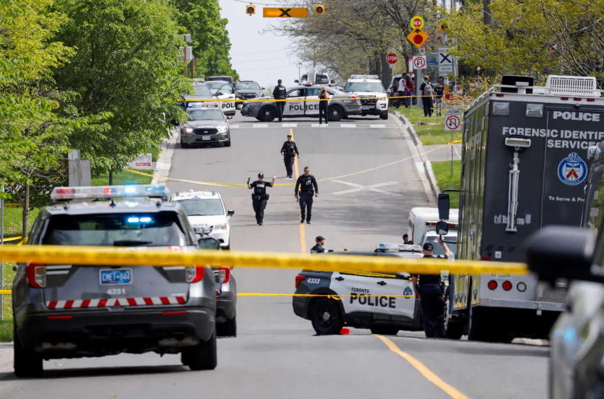 Police officers work at the scene where police shot a suspect who was walking down a city street carrying a gun, in Toronto on May 26, 2022. (Reuters/Chris Helgren)