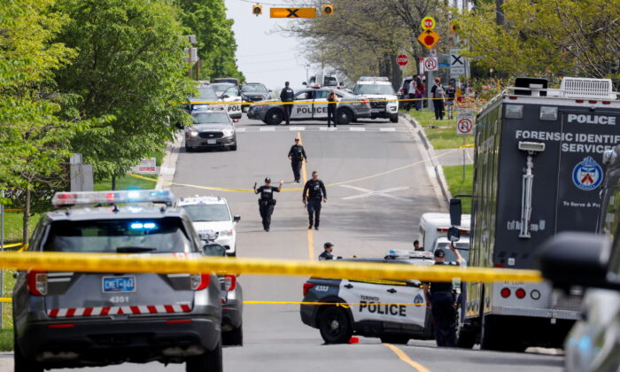 Police officers work at the scene where police shot a suspect who was walking down a city street carrying a gun, in Toronto on May 26, 2022. (Reuters/Chris Helgren)