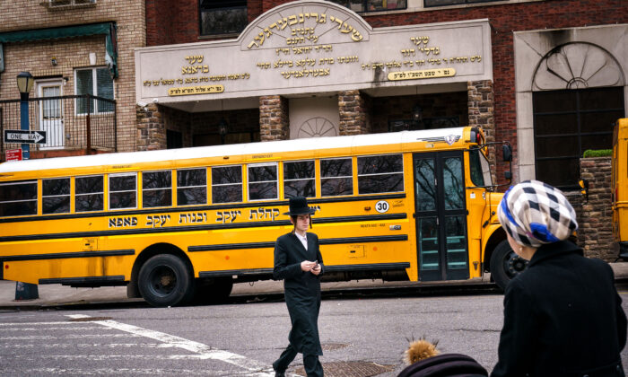 Pedestrians walk past the Yeshiva Kehilath Yakov School in the South Williamsburg neighborhood in the Brooklyn borough of New York City on April 9, 2019. (Drew Angerer/Getty Images)