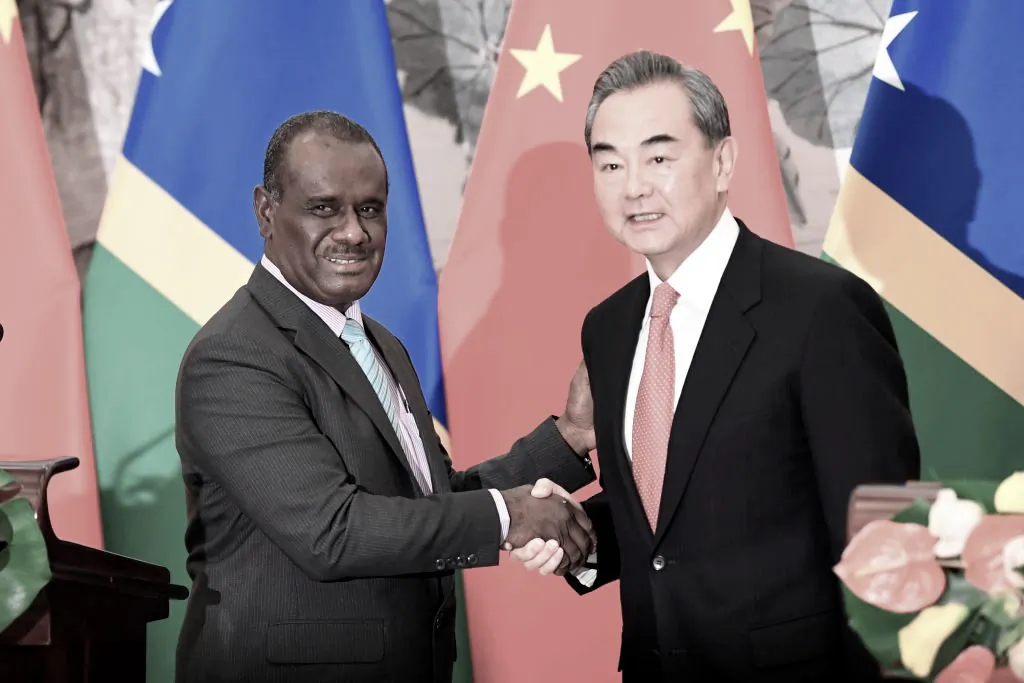Solomon Islands Foreign Minister Jeremiah Manele (L) shakes hands with Chinese State Councilor and Foreign Minister Wang Yi after releasing joint press remarks to mark the establishment of diplomatic ties between the two nations at the Diaoyutai State Guesthouse in Beijing, China on September, 2019. (Naohiko Hatta - Pool/Getty Images)