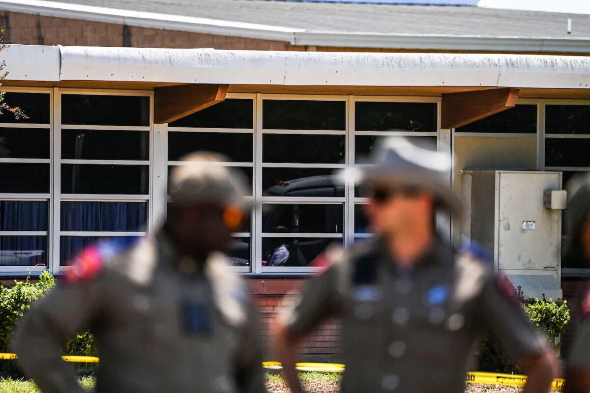 Police officers stand outside the Robb Elementary School in Uvalde, Texas, on May 25, 2022, after a teen in body armor marched into the school and killed 19 children and two teachers. (Chandan Khanna/AFP via Getty Images)