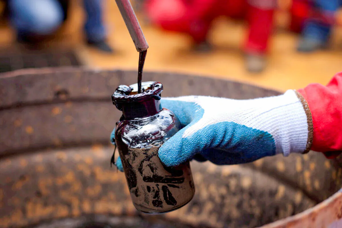 A worker collects a crude oil sample at an oil well operated by Venezuela's state oil company PDVSA in Morichal, Venezuela, on July 28, 2011. (Carlos Garcia Rawlins/Reuters)