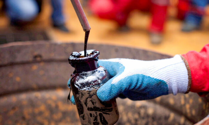 A worker collects a crude oil sample at an oil well operated by Venezuela's state oil company PDVSA in Morichal, Venezuela, on July 28, 2011. (Carlos Garcia Rawlins/Reuters)