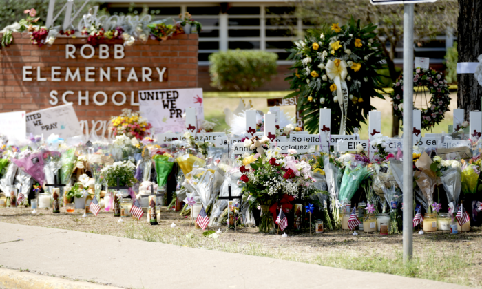 A makeshift memorial at Robb Elementary School is filled with flowers, toys, signs, and crosses bearing the names of all 21 victims of the mass shooting that occurred on May 24, in Uvalde, Texas, on May 27, 2022. (Charlotte Cuthbertson/The Epoch Times) 