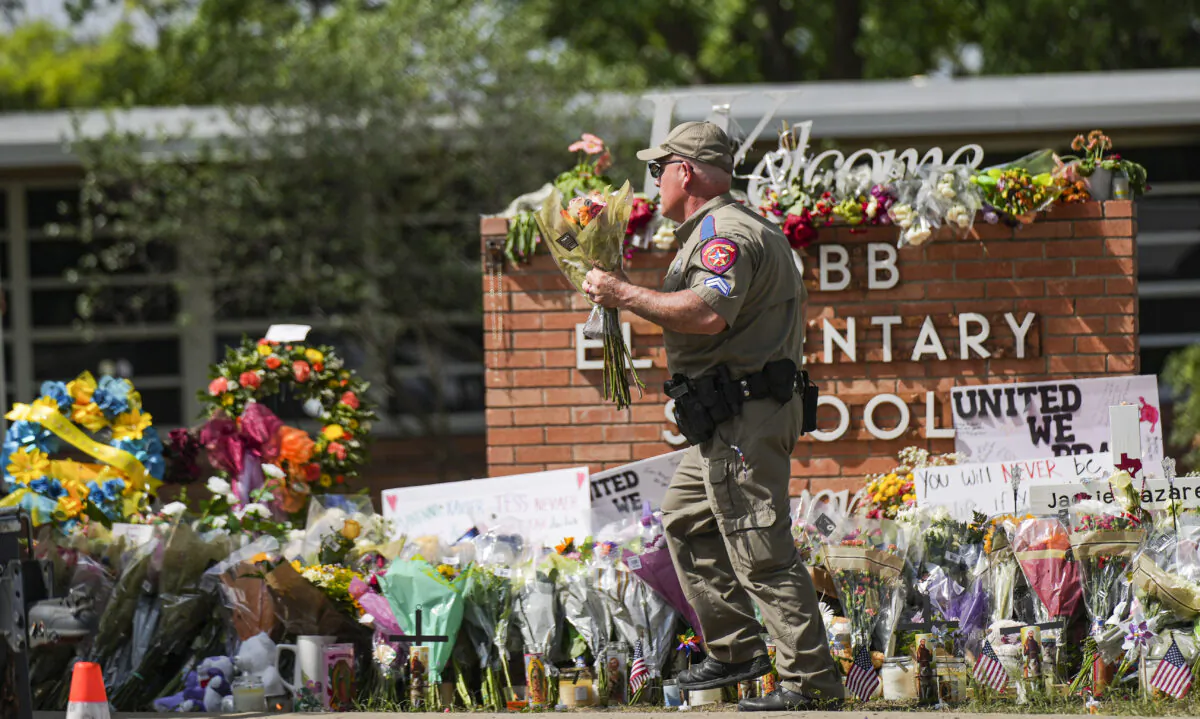 A makeshift memorial at Robb Elementary School is filled with flowers, toys, signs, and crosses bearing the names of all 21 victims of the mass shooting that occurred on May 24, in Uvalde, Texas, on May 27, 2022. (Charlotte Cuthbertson/The Epoch Times)