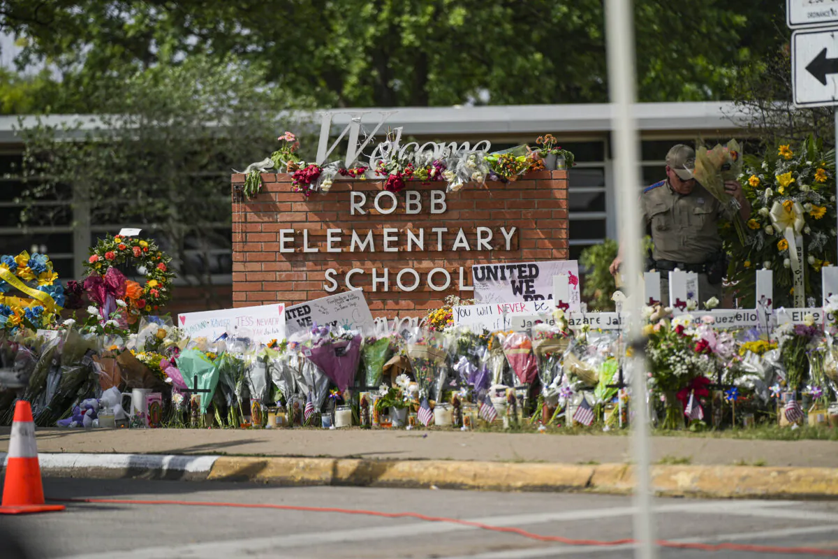 A makeshift memorial at Robb Elementary School is filled with flowers, toys, signs, and crosses bearing the names of all 21 victims of the mass shooting that occurred on May 24, in Uvalde, Texas, on May 27, 2022. (Charlotte Cuthbertson/The Epoch Times)