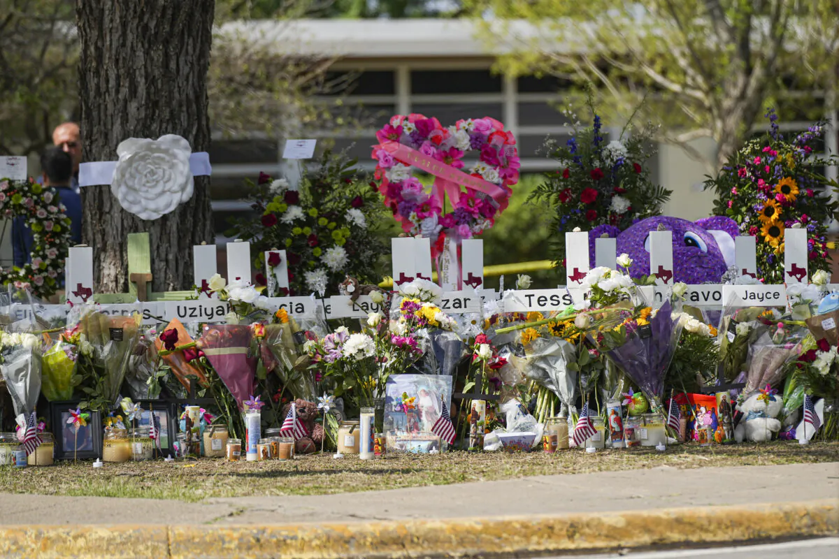 A makeshift memorial at Robb Elementary School is filled with flowers, toys, signs, and crosses bearing the names of all 21 victims of the mass shooting that occurred on May 24, in Uvalde, Texas, on May 27, 2022. (Charlotte Cuthbertson/The Epoch Times)