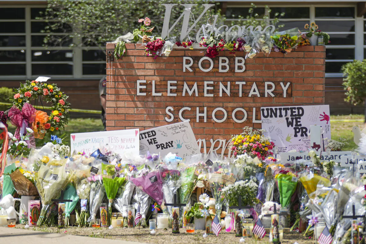 A makeshift memorial at Robb Elementary School is filled with flowers, toys, signs, and crosses bearing the names of all 21 victims of the mass shooting that occurred on May 24, in Uvalde, Texas, on May 27, 2022. (Charlotte Cuthbertson/The Epoch Times)