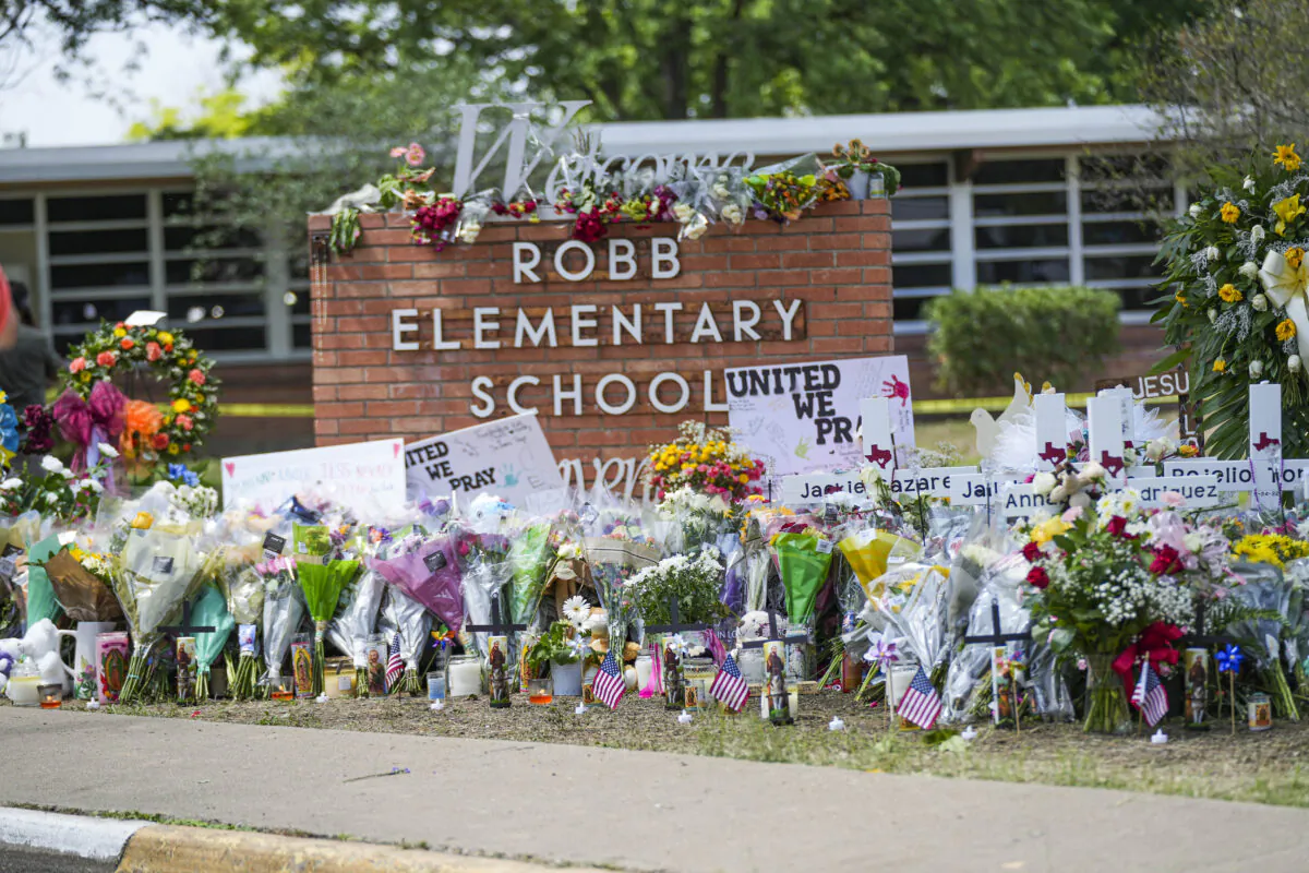 A makeshift memorial at Robb Elementary School is filled with flowers, toys, signs, and crosses bearing the names of all 21 victims of the mass shooting that occurred on May 24, in Uvalde, Texas, on May 27, 2022. (Charlotte Cuthbertson/The Epoch Times)