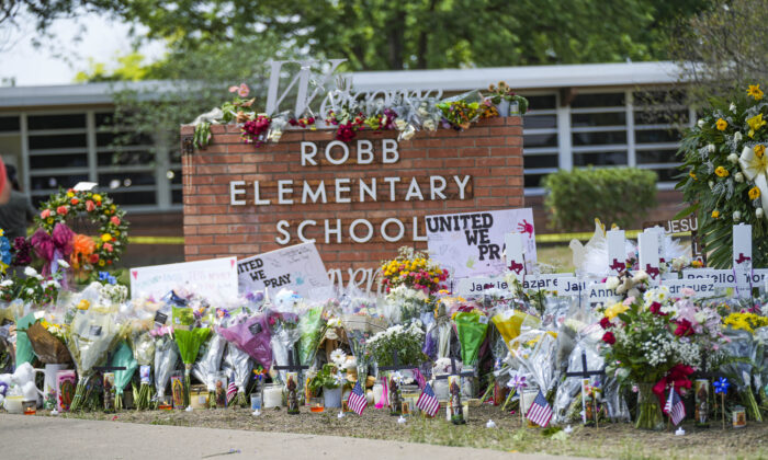 A makeshift memorial at Robb Elementary School is filled with flowers, toys, signs, and crosses bearing the names of all 21 victims of the mass shooting that occurred on May 24, in Uvalde, Texas, on May 27, 2022. (Charlotte Cuthbertson/The Epoch Times)