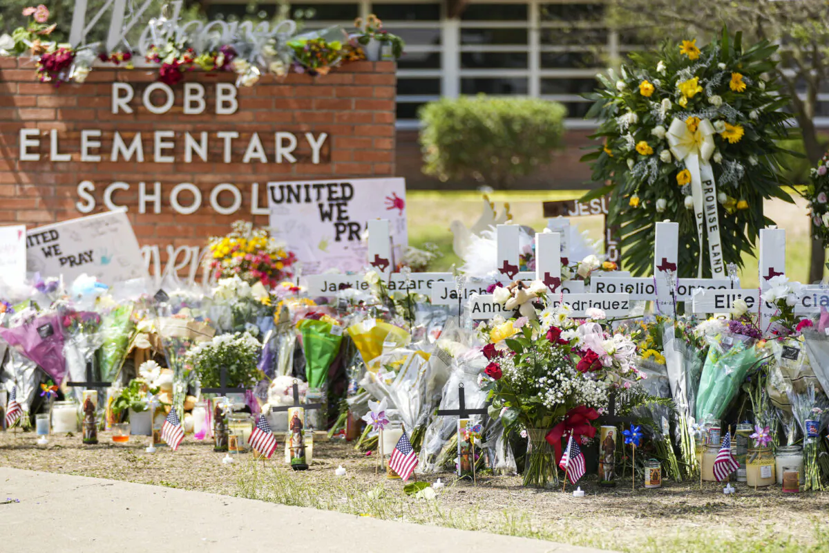 A makeshift memorial at Robb Elementary School is filled with flowers, toys, signs, and crosses bearing the names of all 21 victims of the mass shooting that occurred on May 24, in Uvalde, Texas, on May 27, 2022. (Charlotte Cuthbertson/The Epoch Times)