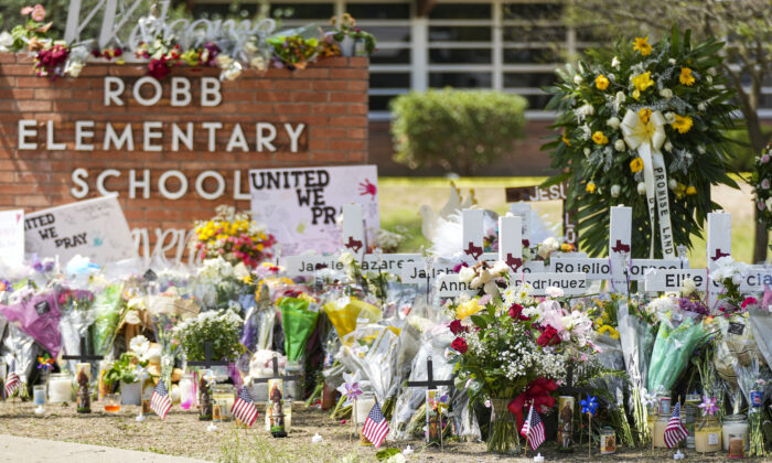 A makeshift memorial at Robb Elementary School is filled with flowers, toys, signs, and crosses bearing the names of all 21 victims of the mass shooting that occurred on May 24, in Uvalde, Texas, on May 27, 2022. (Charlotte Cuthbertson/The Epoch Times)
