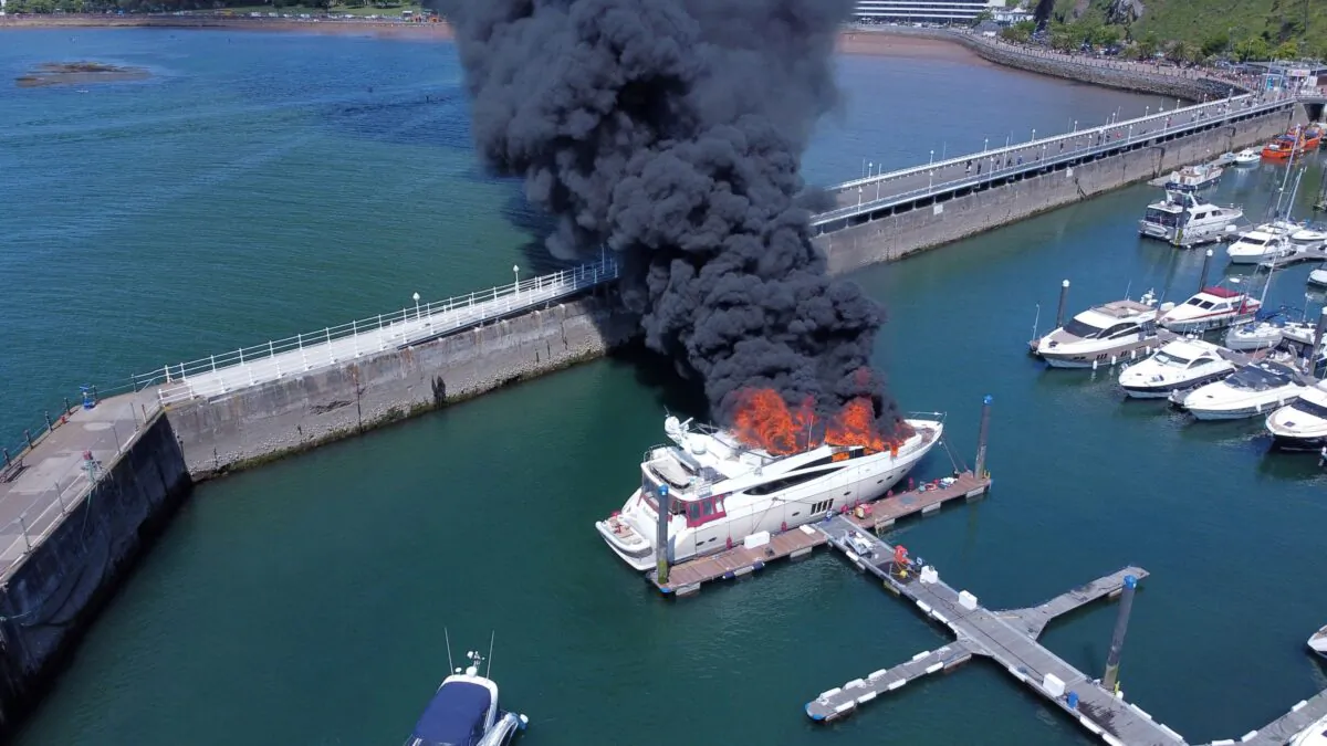 Thick black smoke rises from a fire on a yacht, at Torquay harbour in Torquay, Britain, on May 28, 2022. Picture taken with a drone. (Mike Trower/Handout via Reuters)