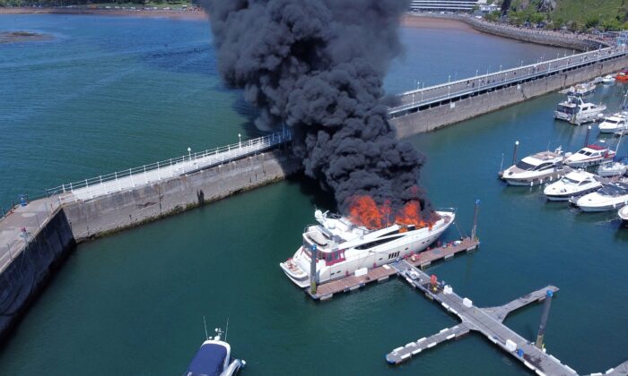 Thick black smoke rises from a fire on a yacht, at Torquay harbour in Torquay, Britain, on May 28, 2022. Picture taken with a drone. (Mike Trower/Handout via Reuters)