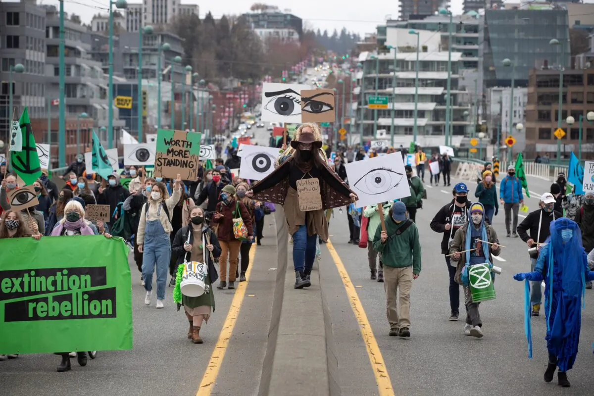 People taking part in a protest against old-growth logging march along Cambie Street Bridge in Vancouver on March 27, 2021. (The Canadian Press/Darryl Dyck)